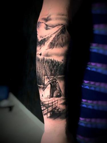 tatuaje realista molino montañas paisaje